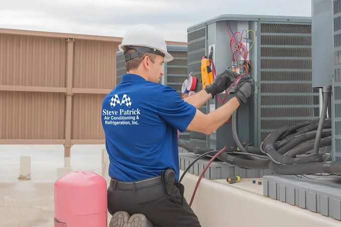 Technician using diagnostic tools on an outdoor air conditioner