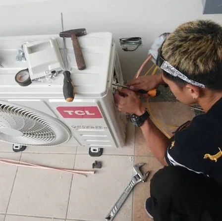 Technician checking the connections on an air conditioning unit