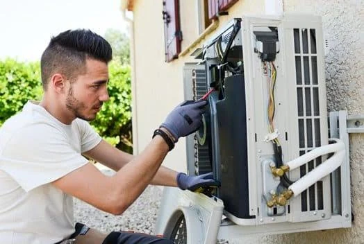 Technician working on outdoor split-system equipment